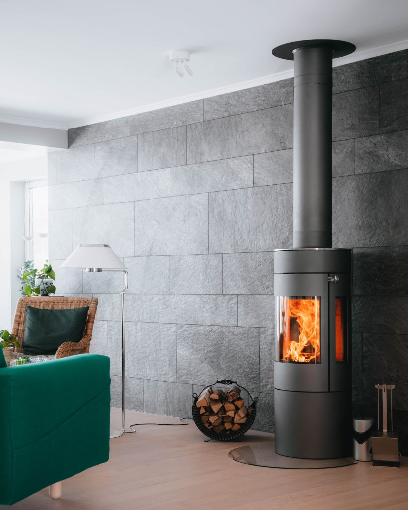 Modern wood burning stove with flue pipe in a stylish living room by Blue Oak Fireplaces Leicester